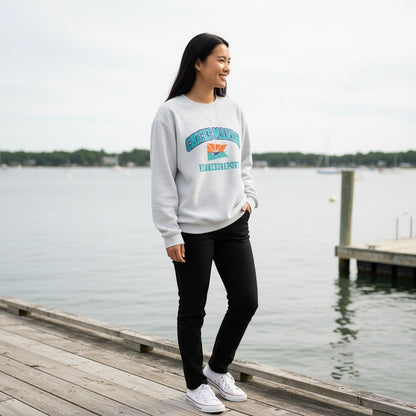 Chicks Marina light grey corduroy crewneck sweatshirt with graphic print on chest, worn by a woman standing on a dock.
