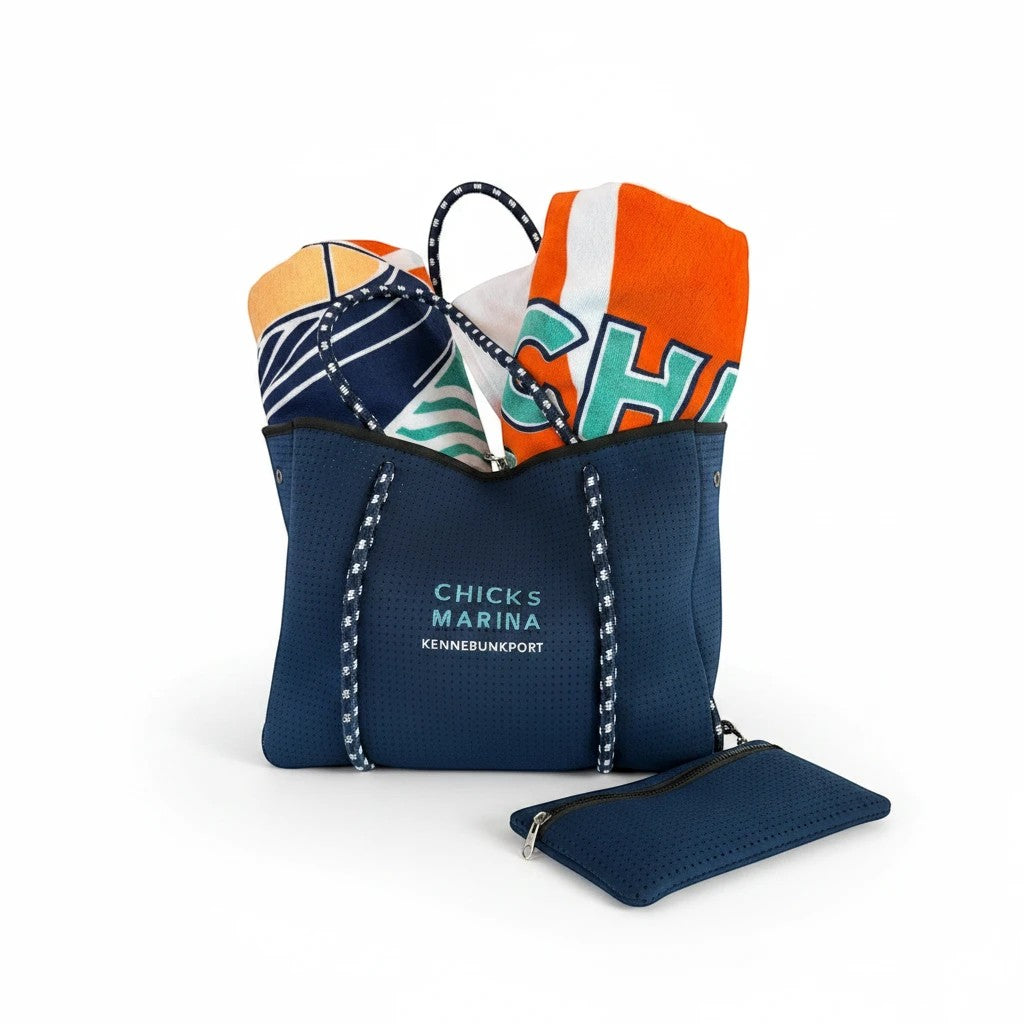 Chicks Marina navy perforated neoprene tote bag with rope handles, filled with beach towels and a matching pouch.