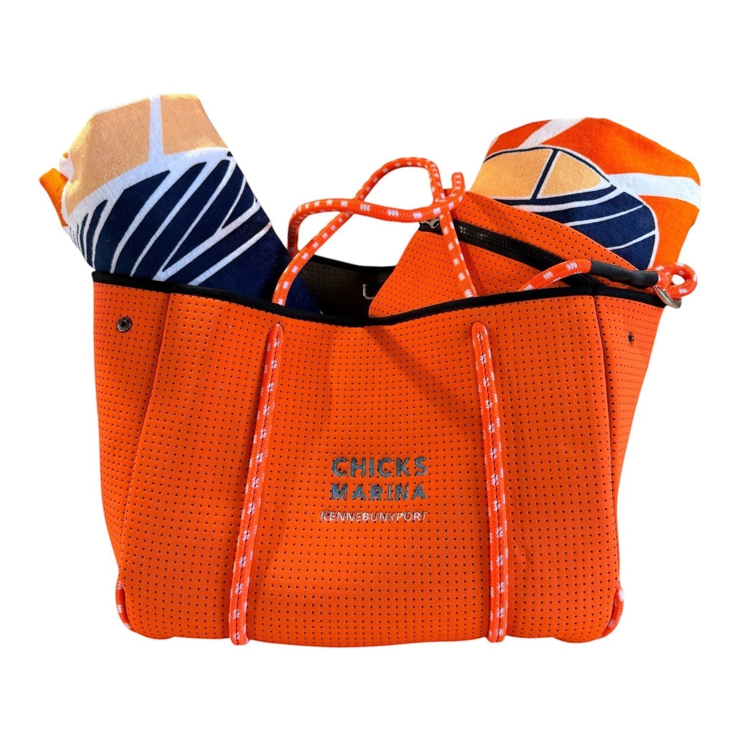 Chicks Marina orange perforated neoprene tote bag with rope handles and beach towel, ideal for coastal travel.