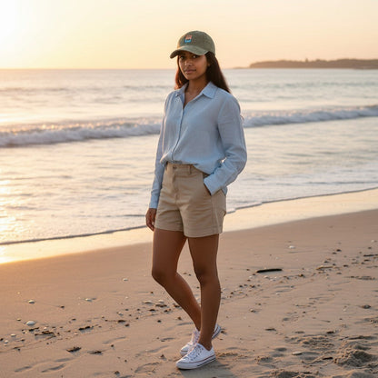 Woman wearing a Chicks Marina salt wash corduroy cap with patch logo on a beach at sunset